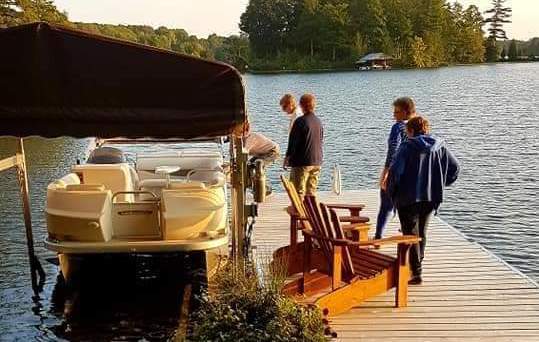 People standing on a dock as the sun sets